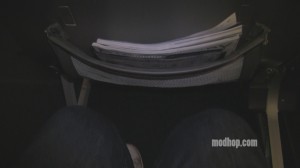 a person's legs and a newspaper in a chair